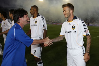 David Beckham y Lionel Messi se dan la mano en la previa de un amistoso entre Barclona y Los Ángeles Galaxy (Photo by Robert Mora/MLS via Getty Images)