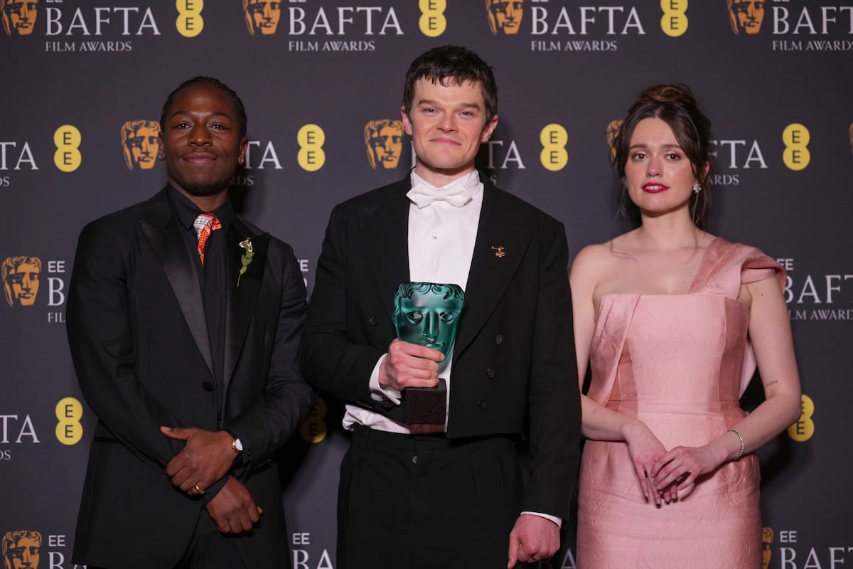 David Jonsson (izq.) y Aimee Lou Wood (der.) rodean a Robert Aramayo, ganador del premio a mejor actor principal por I Swear, durante la gala de los BAFTA donde se reavivó el debate sobre el síndrome de Tourette
