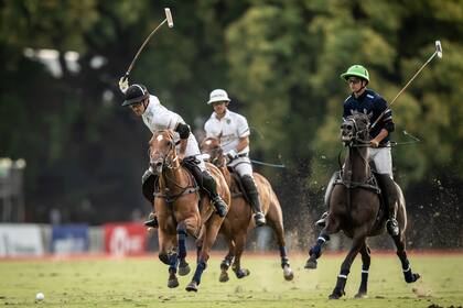 David Stirling está por darle con todo a la bocha; Juan Britos ya sujeta su montado.