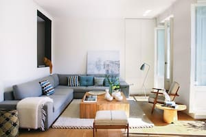 De grandes proporciones y en forma de L, el sofá ‘City soft’ (Sancal) toma las paredes que ofrece el living.