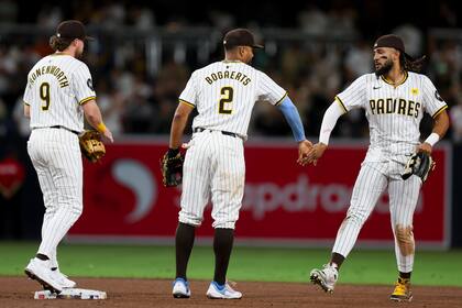De izquierda a derecha, el segunda base de los Padres de San Diego, Jake Cronenworth, el campocorto Xander Bogaerts y el jardinero derecho Fernando Tatis Jr. celebran después de su victoria contra los Medias Blancas de Chicago, el sábado 21 de septiembre de 2024, en San Diego. (AP Foto/Ryan Sun)