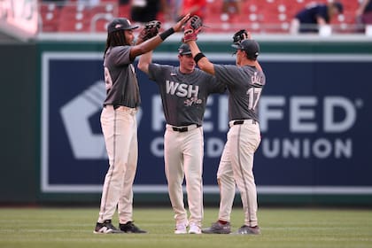 De izquierda a derecha, James Wood, Jacob Young y Alex Call, de los Nacionales de Washington, celebran después de un partido contra los Cerveceros de Milwaukee, el sábado 3 de agosto de 2024, en Washington. (AP Foto/Nick Wass)
