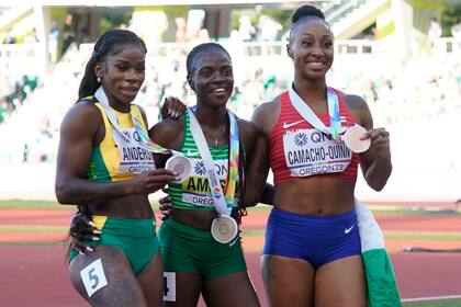 De izquierda a derecha posan la jamaiquina Britany Anderson, la nigeriana Tobi Amusan y la boricua Jasmine Camacho-Quinn, tras la final de los 100 metros con vallas en el Mundial de atletismo, el domingo 24 de julio de 2022, en Eugene, Oregon (AP Foto/Ashley Landis)