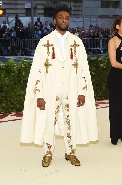 De la película Black Panther, Chadwick Boseman de blanco con detalles de cruces y piedras brillantes