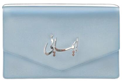De satén y en color celeste, el clutch, de Jennifer Chamandi, dice “Imany”, una palabra árabe que significa ‘Mi fe’ y también ‘Mi Iman’. Usó el mismo accesorio para la boda de su hija, la princesa Iman.