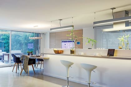 De un lado de la barra, banquetas italianas (Magis). Del otro, separado por el frente de Corian, se encuentra la cocina.