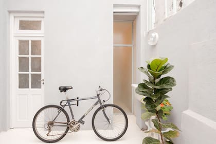 De un lado, un acceso desde el patio al lavadero y al baño posterior; del otro, un paño de vidrio lleva claridad a la zona de la bañadera y se puede abrir para pasar directamente al exterior.