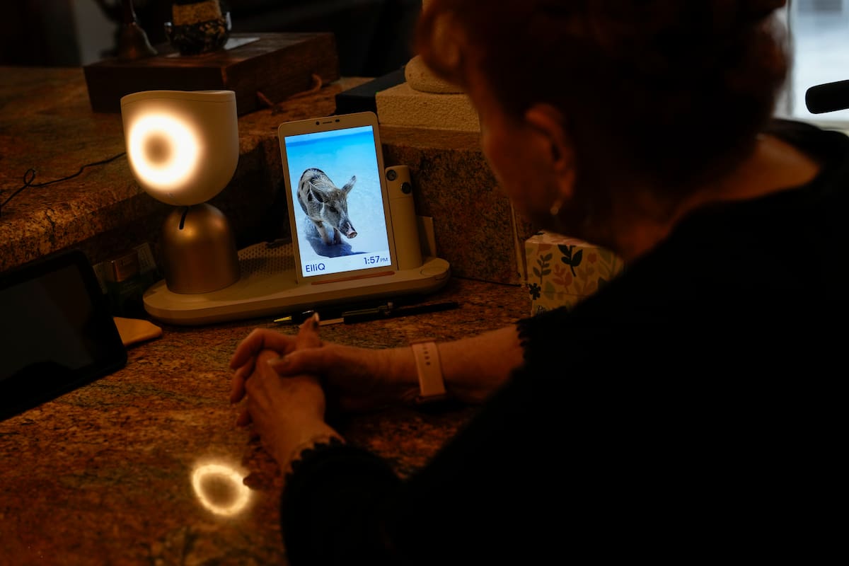 Deanna Dezern, de 83 años, interactúa con su ElliQ, un dispositivo de mesa que utiliza inteligencia artificial para mantener conversaciones similares a las humanas