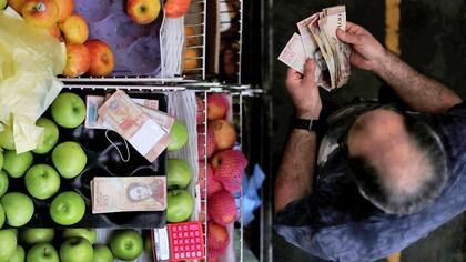 Decenas de billetes para hacer una compra básica en Venezuela