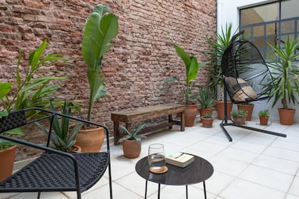 Dejaron la pared del patio con ladrillos a la vista para mantener la impronta de un PH centenario. Los baldosones son atérmicos, no resbalan y son de fácil colocación y mantenimiento.
