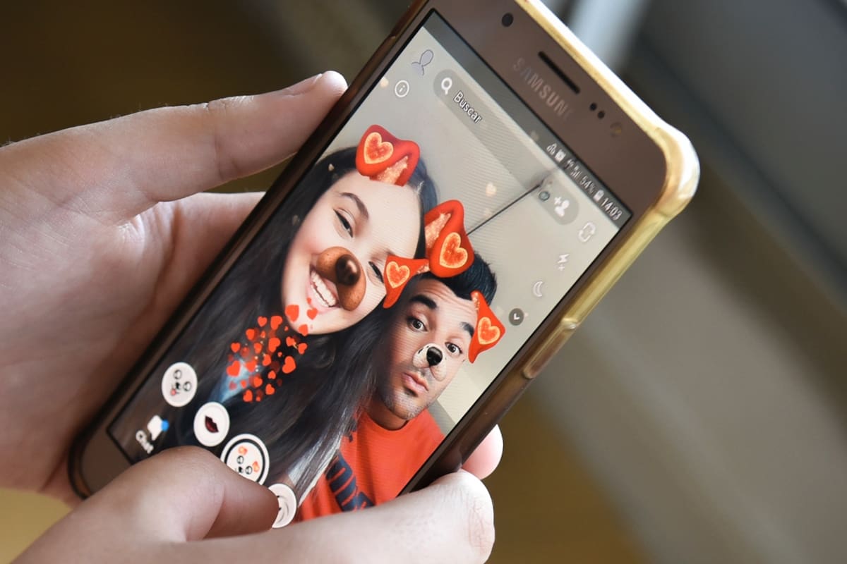 Delfina Semelis, de 11 años, con la app de Snapchat en su celular