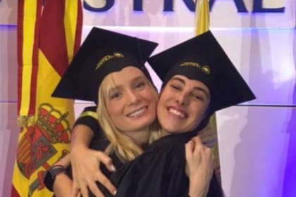 Delfina Lanusse y Chantal Leclercq se abrazan y sonríen durante un acto de graduación, ambas con toga y birrete en la universidad Austral