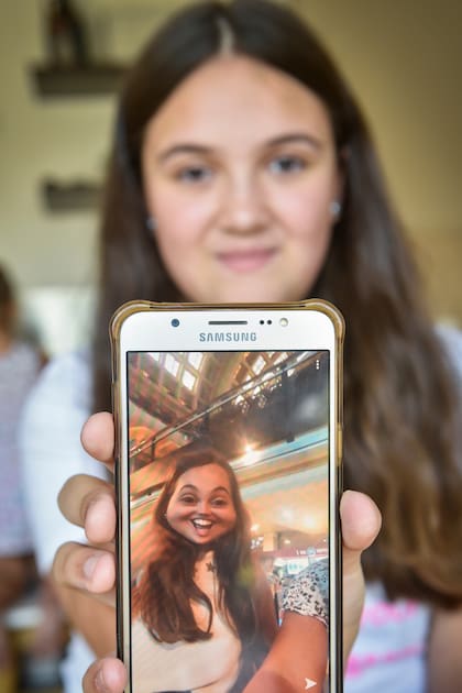 Delfina, de 11 años, enseñándole a su padre Matías Semelis a usar la app de Snapchat