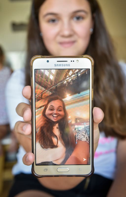 Delfina Semelis, de 11 años, con la app de Snapchat en su celular