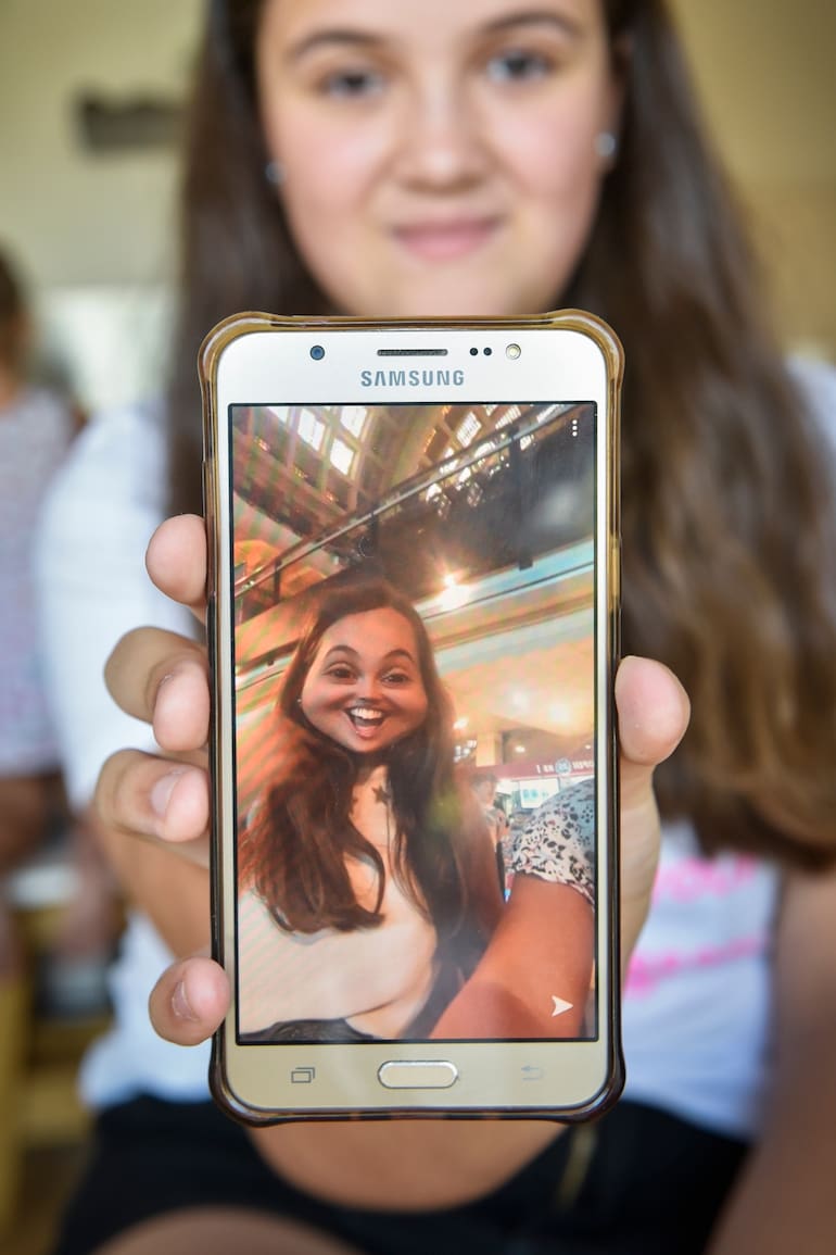 Delfina Semelis, de 11 años, con la app de Snapchat en su celular