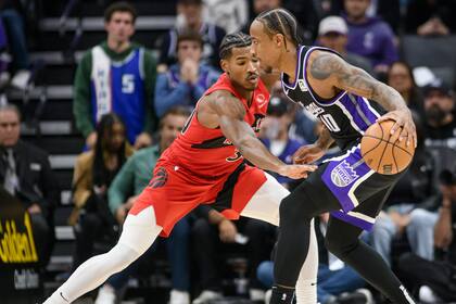DeMar DeRozan, de los Kings de Sacramento, y Ochai Agbaji, de los Raptors de Toronto, se encaran en el partido del miércoles 6 de noviembre de 2024 (AP Foto/Randall Benton)