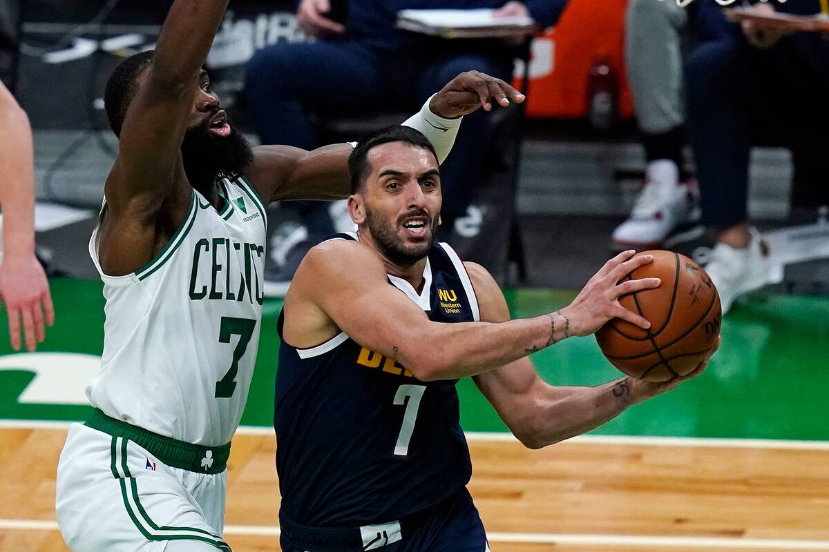 Denver Nuggets guard Facundo Campazzo, right, drives to the basket against Boston Celtics guard Jaylen Brown, left, during the first half of an NBA basketball game, Tuesday, Feb. 16, 2021, in Boston. (AP Photo/Charles Krupa)