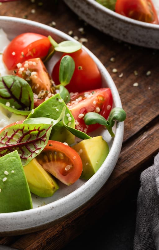 Desayuno saludable en un plato, huevo, ensalada de aguacate con tomate y semillas de cáñamo