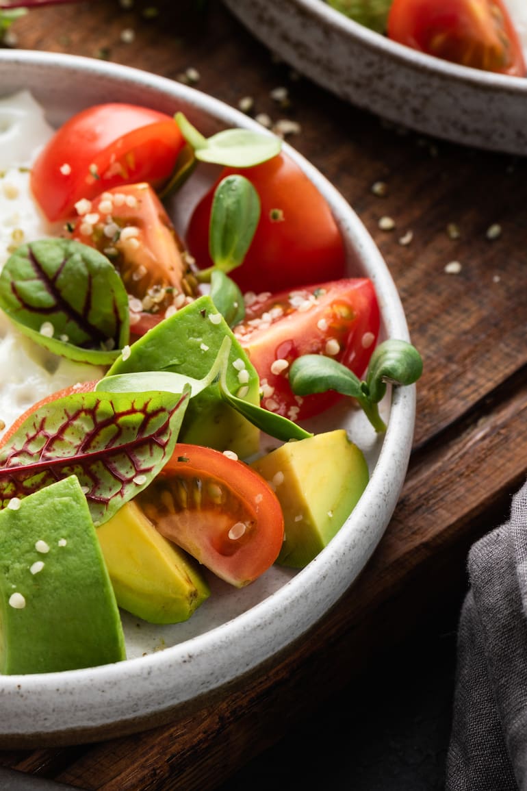 Desayuno saludable en un plato, huevo, ensalada de aguacate con tomate y semillas de cáñamo