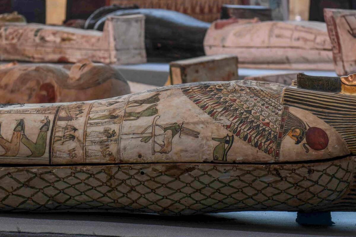 Una arqueóloga limpia una de las esculturas halladas junto alos sarcófagos
