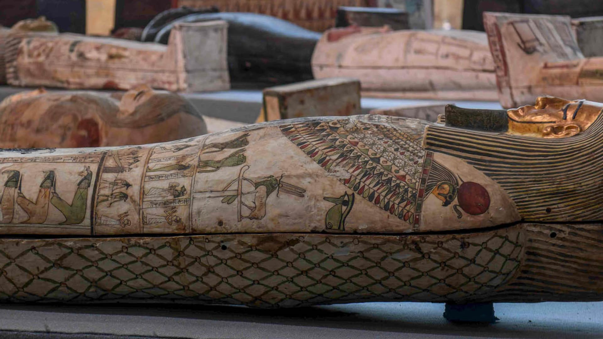 Una arqueóloga limpia una de las esculturas halladas junto alos sarcófagos