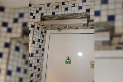 El hombre dispuso el artefacto por encima de la puerta de entrada del sanitario, en una parte del cielorraso que había sido removida por reparaciones.