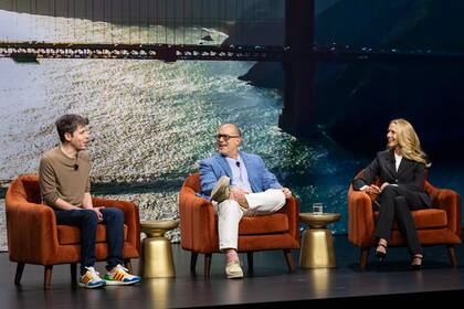 Desde la izquierda, Sam Altman, Jonathan Ive -el legendario diseñador detrás del iPhone- y Lauren Powell Jobs (la empresaria y viuda de Steve Jobs) en el Demo Day de Emerson Collective, hablando, en 2025, sobre avances en el proyecto que promete redefinir la era post-smartphone