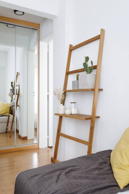 Desde la L del sofá se ve el placard espejado que ilumina el pasillo y le da profundidad al living. Escalera-repisa (Casa Leopoldo)