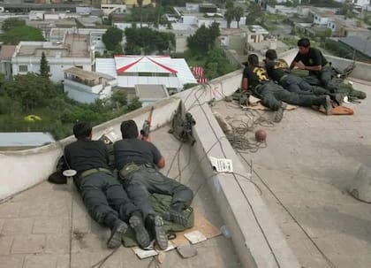 Desde los techos linderos, los miembros de la Unidad Antiterrorista del Perú observan la residencia del embajador con aguda atención