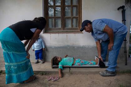 Una asistente de salud de la comunidad Misión La Paz toma medidas de talla y peso