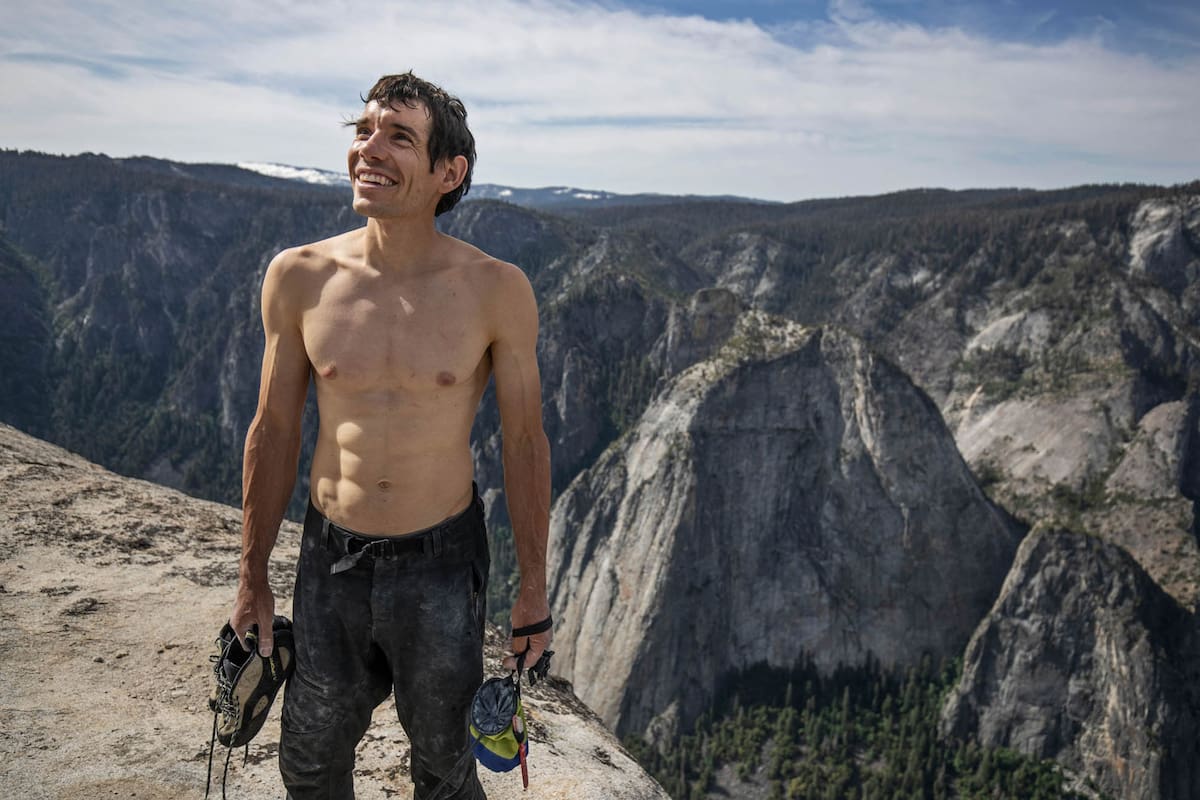 Después de casi cuatro horas de escalada libre, llega a la cima de El Capitán y sonríe.