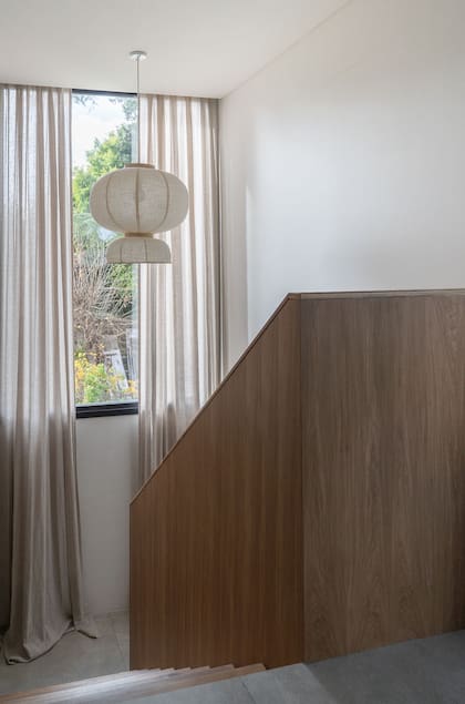 Detalle del larguísimo cortinado en el ascenso con baranda de madera.