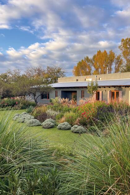 Detrás de la casa se aprecian los carolinos con colores otoñales