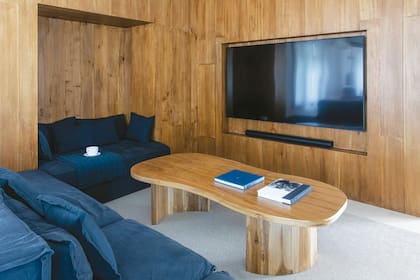 Detrás de la pared de madera, hay lugar de guardado para "esas típicas cosas que una nunca sabe dónde poner”. Mesa ‘Poroto’ (Lau Interiors). Sillón de tussor diseñado por Anush y Cris.