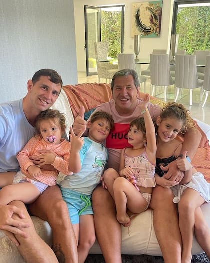 Dibu Martínez "le hace upa" a su hija Ava; a su lado, sentados sobre un sillón, se encuentran su hijo mayor, Santiago; su padre, Alberto; y sus sobrinas