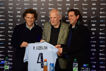 Diego Forlan y una imagen con emoción, junto con Pablo, su padre, y el presidente de la Asociación Uruguaya, Ignacio Alonso, durante la presentación en el estadio Centenario