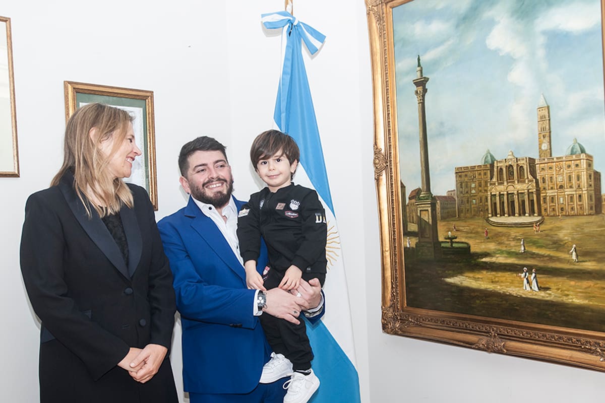 Diego Jr. y su hijo Diego Matías, posan junto a la cónsul general, Ana Tito y a la bandera argentina (Prensa Consulado argentino en Roma)
