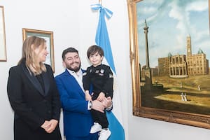 Diego Jr. y su hijo Diego Matías, posan junto a la cónsul general, Ana Tito y a la bandera argentina (Prensa Consulado argentino en Roma)