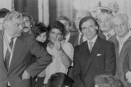Diego Maradona y el presidente Carlos Menem, en el agasajo que el seleccionado argentino tuvo en la Casa Rosada por el subcampeonato en Italia 90; a la izquierda, el PF Ricardo Echevarría y, a la derecha, Antonio Cafiero