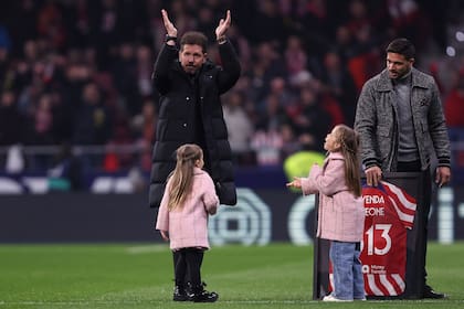 Diego Simeone, acompañado por sus hijos Giovanni, Francesca y Valentina, retribuye el saludo de los hinchas de Atlético de Madrid, tras marcar el récord de 613 partidos como DT colchonero.