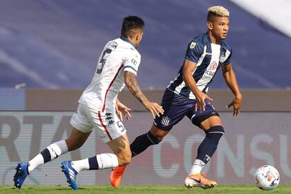 Diego Valoyes conduce la pelota, ante la marca de Francisco Ortega: Talleres cayó de local ante Velez.