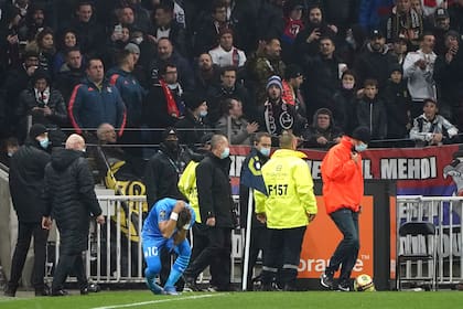 Dimitri Payet del Marsella reacciona tras ser agredido por un proyectil lanzado desde la grada durante el partido contra Lyon por la liga francesa, el domingo 21 de noviembre de 2021. (AP Foto/Laurent Cipriani)