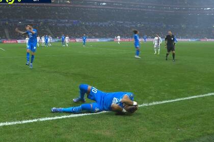 Dimitri Payet tendido en el piso luego de recibir el impacto de una botella que voló desde la triubuna