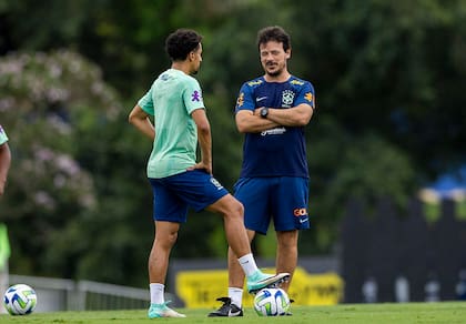 Diniz conversa con Marquinhos, el capitán de Brasil, antes del entrenamiento del domingo