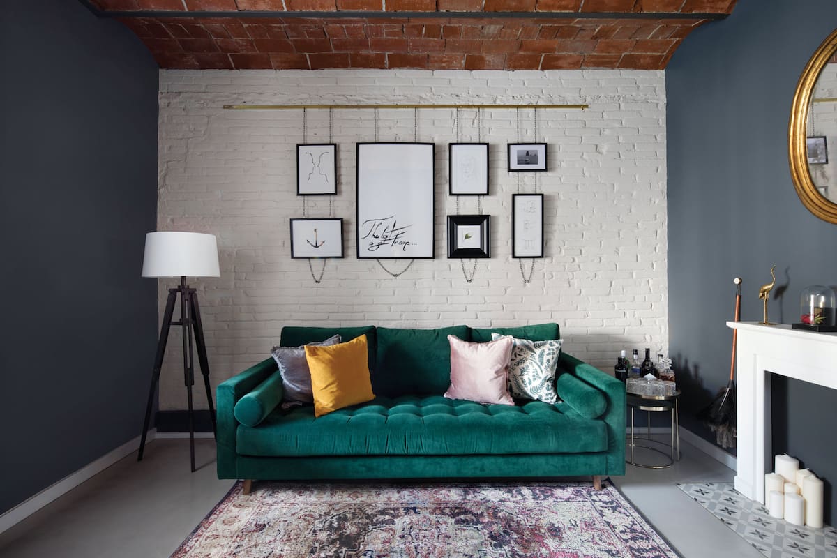 “Diseñé el sofá y lo tapicé en pana verde porque me gusta cómo combina con el gris. A la idea de los cuadros la tomé del club Soho House de Barcelona. Quedan bien sobre los ladrillos, que pinté de blanco iluminar este living cerrado”, dice Paulo.
