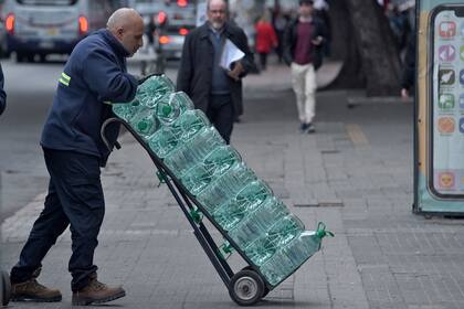 Distribución de agua potable en un supermercado en Montevideo. (Dante FERNANDEZ / AFP)