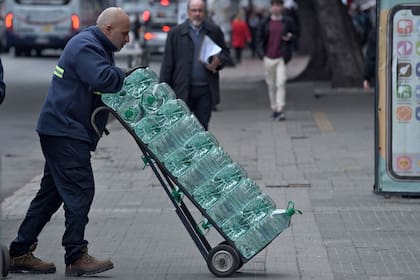 Distribución de agua potable en un supermercado en Montevideo. (Dante FERNANDEZ / AFP)