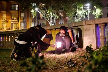 Manifestantes encienden una bengala para arrojarla a la policía