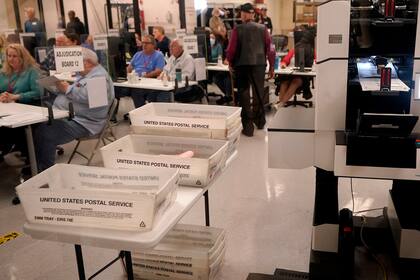 Diversas personas observan el conteo de votos en la Oficina de Registradores del condado Maricopa, en Phoenix, el miércoles 9 de noviembre de 2022. (AP Foto/Matt York)