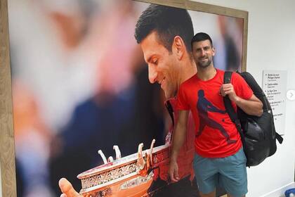Djokovic posa junto al poster que lo muestra como campeón de Roland Garros